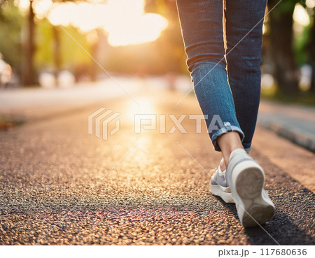 スニーカーで歩く女性の足元（元気,若い,一人,足元,朝日,夕日,逆光） 117680636