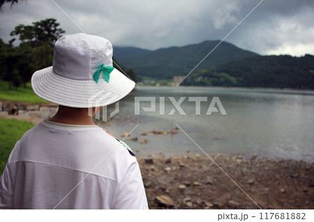 A quiet summer walk along the beach in the park with an elderly Asian mother and daughter holding hands 117681882