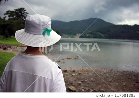 A quiet summer walk along the beach in the park with an elderly Asian mother and daughter holding hands 117681883