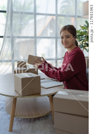woman, online seller, efficiently manages customer orders and delivery through the e-commerce platform 117681963