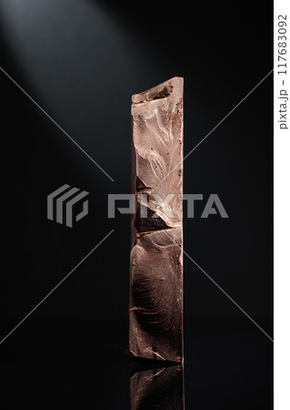 Large piece of dark chocolate. 117683092