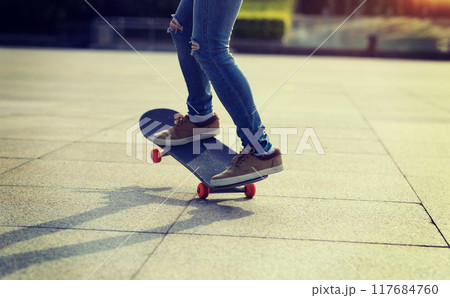 Skateboarder riding skateboard in city 117684760