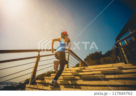 Healthy lifestyle sports woman running up on stone stairs at sunrise seaside Healthy lifestyle sports woman running up on stone stairs at sunrise seaside 117684762