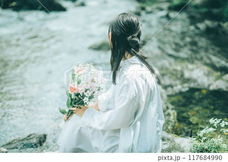 白いワンピースで夏の川に入っている女性の後ろ姿 白いワンピースで夏の川に入っている女性の後ろ姿 117684990