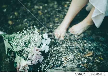 白いワンピースで夏の川に入っている女性の足元と花束 白いワンピースで夏の川に入っている女性の足元と花束 117685007