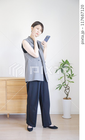 スマホを操作する女性の全身 117687120