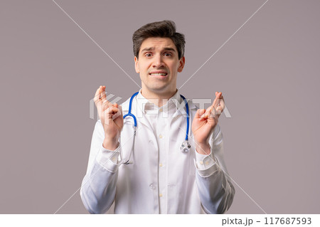 Mature 30s doctor man Praying With Crossed Fingers, Begs Apologize, Guilty on White. Hopeful Prayer 117687593