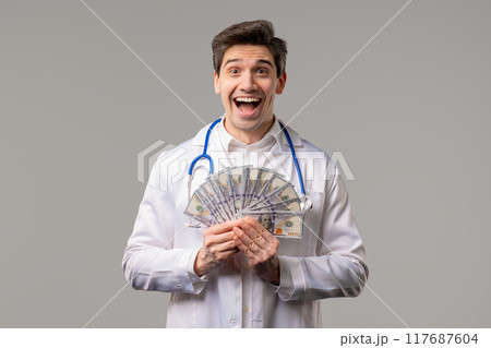 Rich Doctor Man with Usd money. Handsome Medical Health Care Worker In White Coat with salary, payment. Jackpot, win 117687604