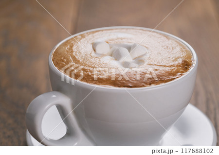 fresh cappuccino with marshmallow on wood oak table 117688102
