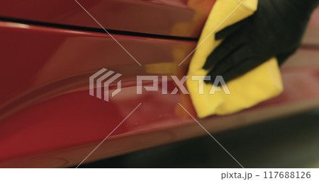 closeup of wiping red car with microfiber cloth 117688126