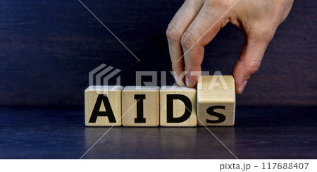 Symbol for helping people with aids, Acquired immunodeficiency syndrome. Doctor turns a wooden cube with words aids aid. Beautiful grey background, copy space. Medical and aids aid concept. 117688407