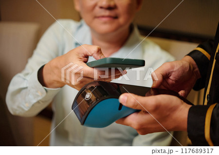 Man Using Smartphone To Pay For Bill In The Restaurant 117689317