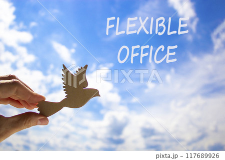 Flexible office symbol. Concept words Flexible office on beautiful sky. Beautiful blue sky cloud background. Businessman hand with wooden bird. Business Flexible office concept. Copy space. Flexible office symbol. Concept words Flexible office on beautiful sky. Beautiful blue sky cloud background. Businessman hand with wooden bird. Business Flexible office concept. Copy space. 117689926