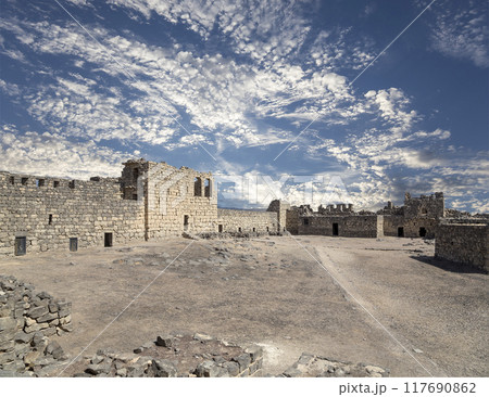 Ruins of Azraq Castle (Qasr al-Azraq) is a crusader castle (300AD), central-eastern Jordan, 100 km east of Amman, Jordan. Against the background of a beautiful sky with clouds Ruins of Azraq Castle (Qasr al-Azraq) is a crusader castle (300AD), central-eastern Jordan, 100 km east of Amman, Jordan. Against the background of a beautiful sky with clouds 117690862