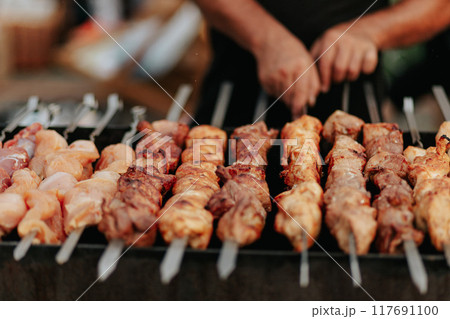 Frying shish kebab on the skewers in brazier. Fresh ruddy meat for barbecue grill on fire outdoor. Frying shish kebab on the skewers in brazier. Fresh ruddy meat for barbecue grill on fire outdoor. 117691100