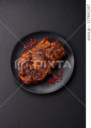 Fresh juicy delicious beef steak on a dark background 117691267