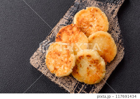 Delicious fresh sweet cheese pancakes with raisins and cinnamon Delicious fresh sweet cheese pancakes with raisins and cinnamon 117691434