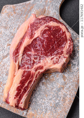 Fresh, raw beef steak with salt, spices and herbs 117691482