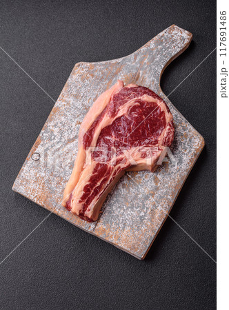 Fresh, raw beef steak with salt, spices and herbs Fresh, raw beef steak with salt, spices and herbs 117691486