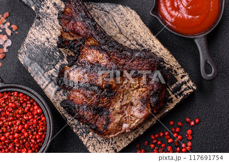 Juicy grilled beef tomahawk steak with salt, spices and herbs 117691754