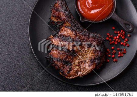 Juicy grilled beef tomahawk steak with salt, spices and herbs 117691763
