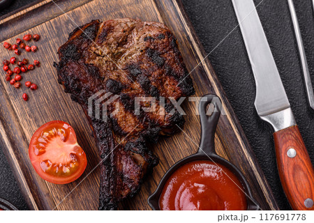 Juicy grilled beef tomahawk steak with salt, spices and herbs 117691778
