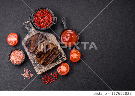 Fresh juicy delicious beef steak on a dark background Fresh juicy delicious beef steak on a dark background 117691828