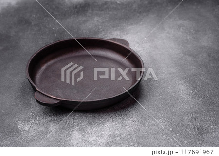 Empty ceramic plate on a dark textured background Empty ceramic plate on a dark textured background 117691967