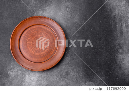 Empty ceramic plate on a dark textured background 117692000
