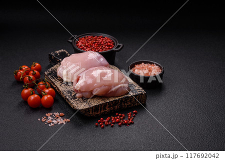 Fresh chicken fillet on a dark concrete table with spices and herbs Fresh chicken fillet on a dark concrete table with spices and herbs 117692042