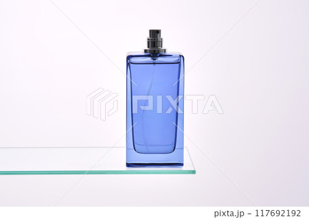 Perfume spray in a blue bottle on a white background. 117692192