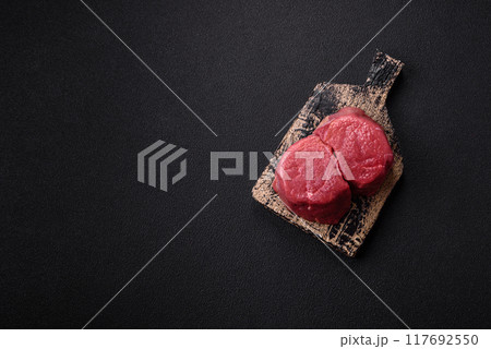 Fresh juicy raw beef medallions with salt and spices 117692550