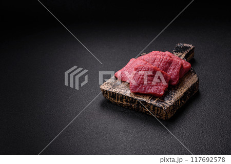 Juicy fresh raw beef meat with salt, spices and herbs Juicy fresh raw beef meat with salt, spices and herbs 117692578