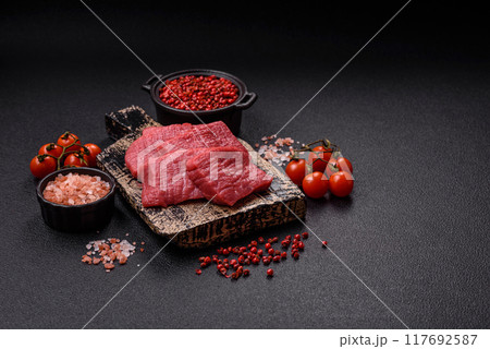 Juicy fresh raw beef meat with salt, spices and herbs 117692587