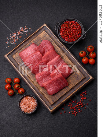 Juicy fresh raw beef meat with salt, spices and herbs 117692613