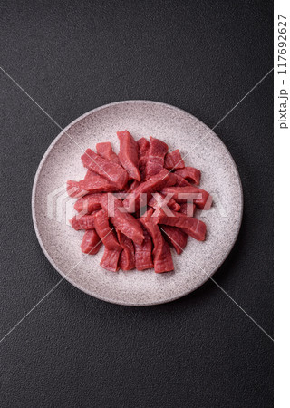 Juicy fresh raw beef meat with salt, spices and herbs Juicy fresh raw beef meat with salt, spices and herbs 117692627