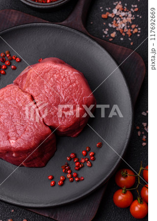 Fresh juicy raw beef medallions with salt and spices Fresh juicy raw beef medallions with salt and spices 117692669
