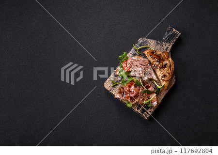 Variation of several toasts or bruschetta with prosciutto, mushrooms and veal 117692804
