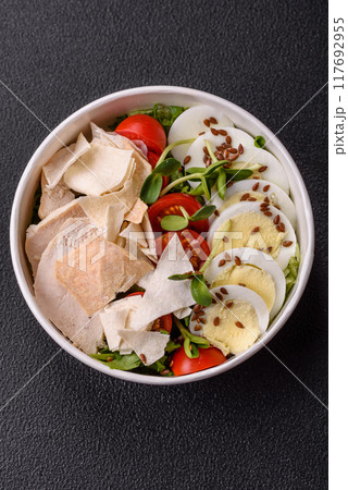 Delicious fresh caesar salad in a bowl with chicken breast, egg, tomatoes 117692955