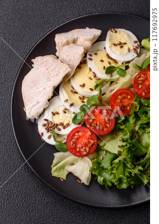 Delicious fresh caesar salad in a bowl with chicken breast, egg, tomatoes 117692975