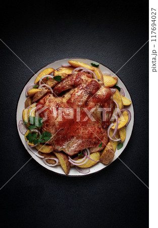 fried, baked chicken, in the oven, with spices, and rustic potatoes, top view, homemade, 117694027