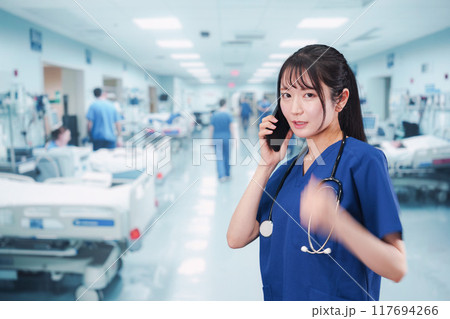 忙しく急患の対応をする若い女性ドクター 117694266