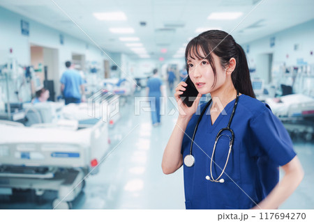 忙しく急患の対応をする若い女性ドクター 117694270