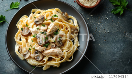 Creamy fettuccine Alfredo with mushrooms and chicken on a dark rustic table Creamy fettuccine Alfredo with mushrooms and chicken on a dark rustic table 117694554