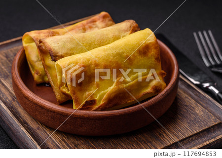 Homemade fried pancakes with filling on a ceramic plate Homemade fried pancakes with filling on a ceramic plate 117694853
