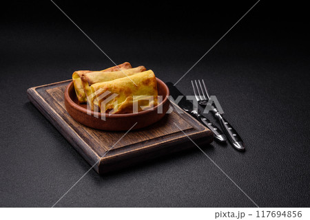 Homemade fried pancakes with filling on a ceramic plate 117694856