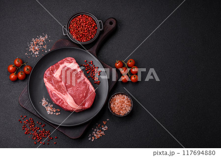 Fresh, raw beef steak with salt, spices and herbs 117694880
