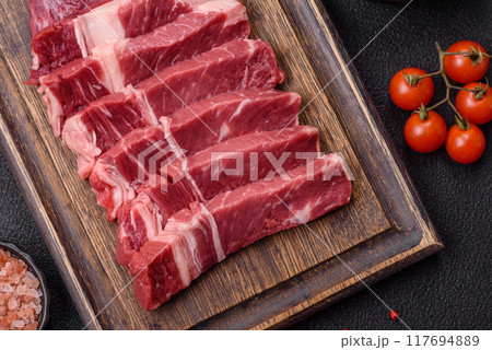 Fresh raw beef cut into slices with salt, spices 117694889