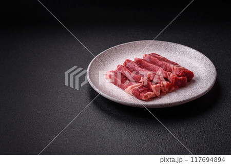 Fresh raw beef cut into slices with salt, spices 117694894