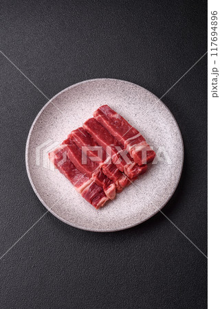 Fresh raw beef cut into slices with salt, spices 117694896